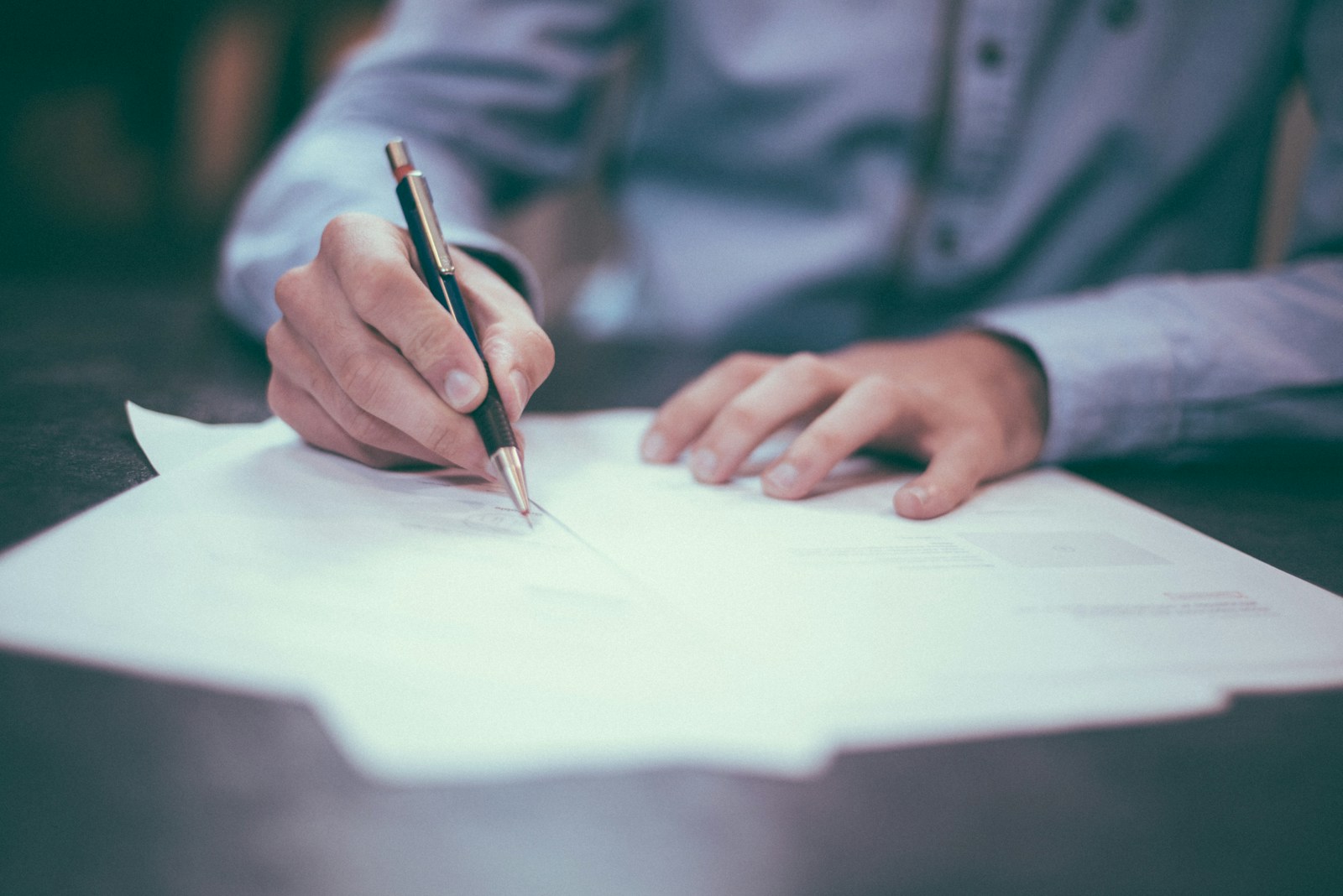 man writing on paper Policy That Combines Different Types of Commercial Insurance